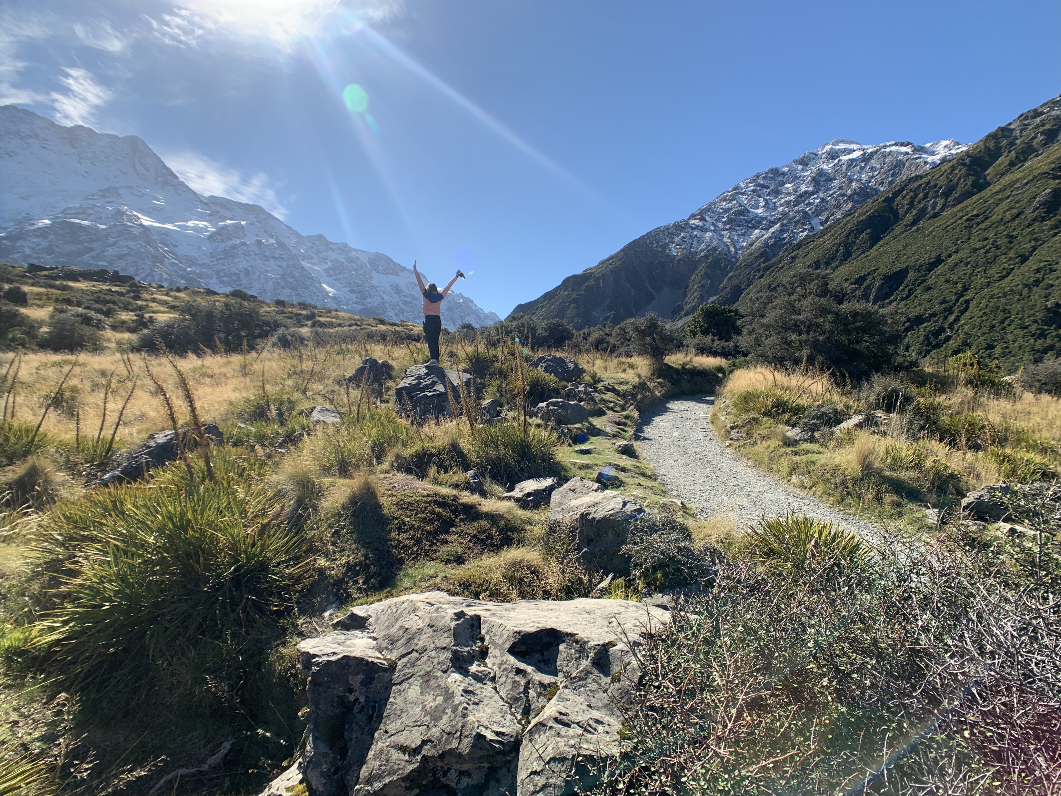 Girl standing on rock in Mount Cook National Park, New Zealand.