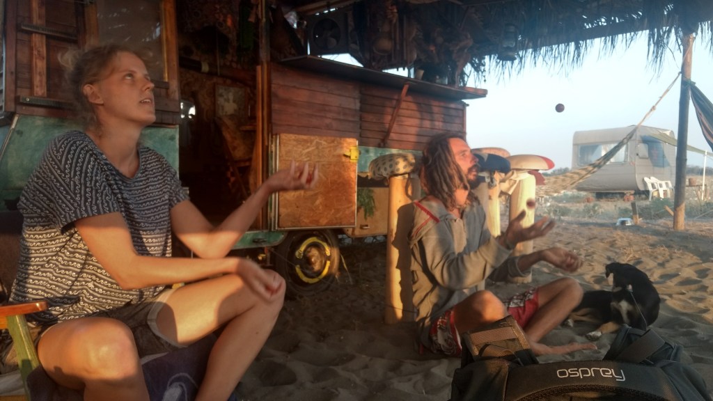A man and woman juggle in a beach shack in Montenegro.