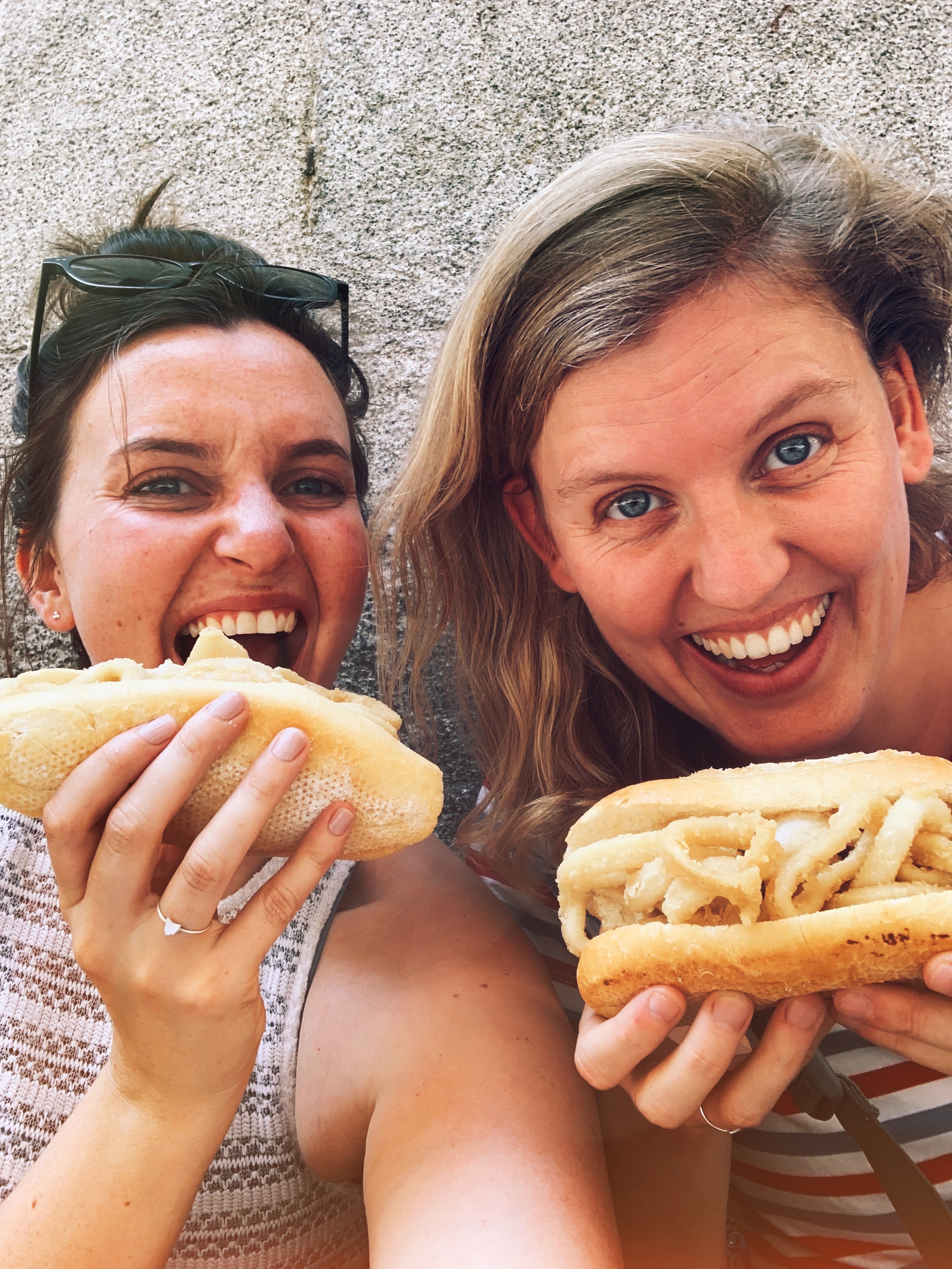Two girls eat bocadillo de calamares in Madrid, Spain