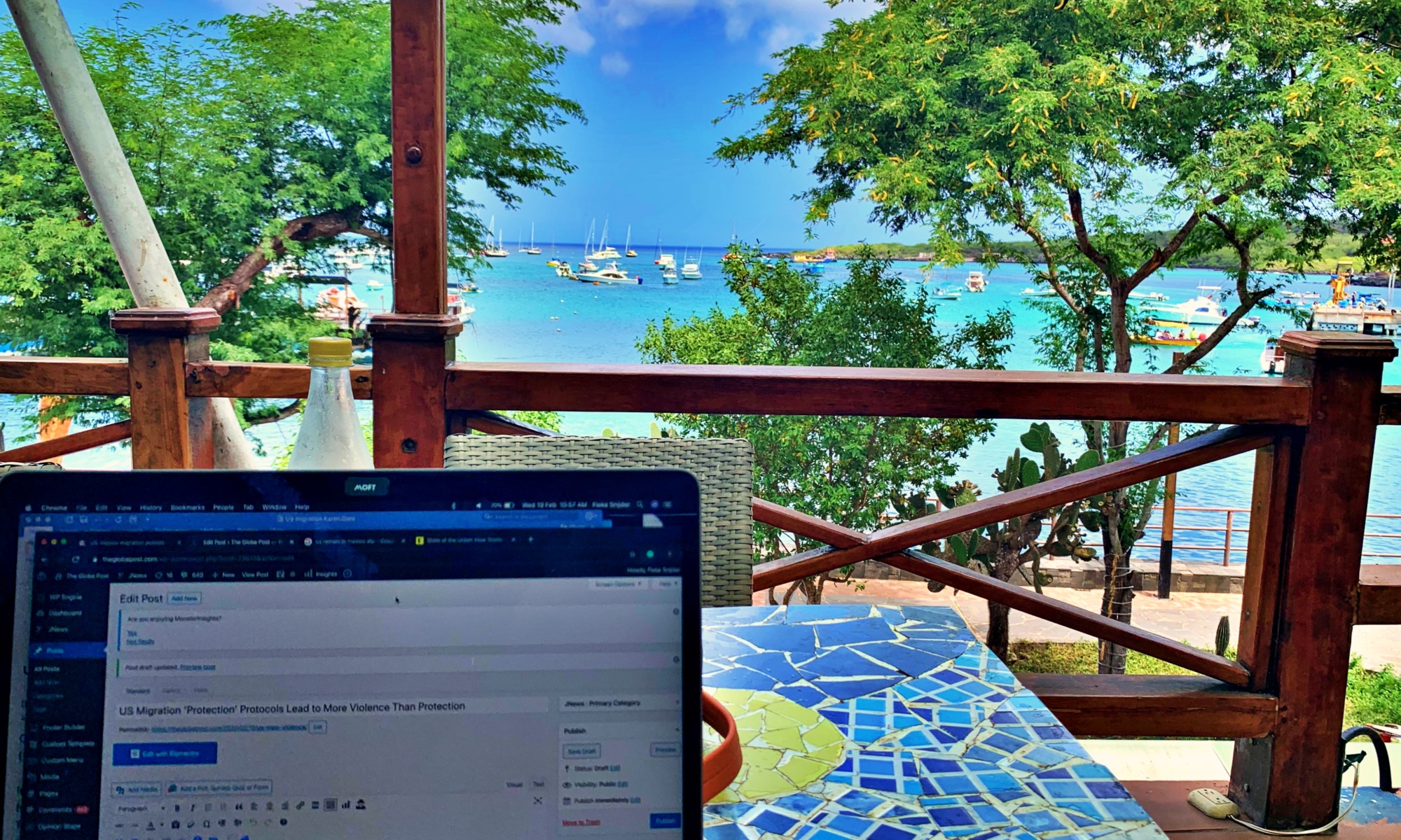 photo-of-laptop-on-table-with-galapagos-island-in-background
