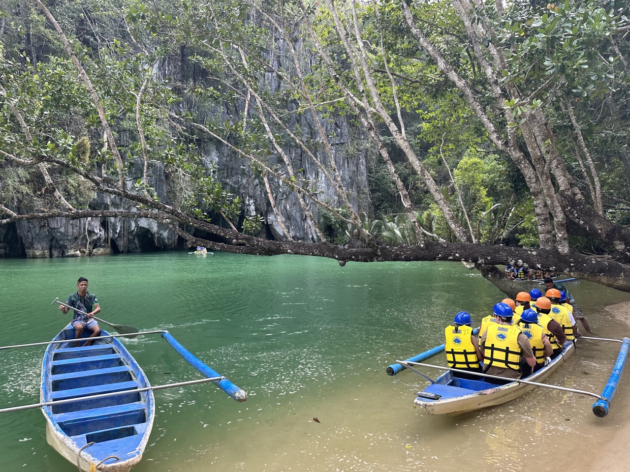 photo-of-two-canoes-and-people-inside-on-green-water-with-trees-around